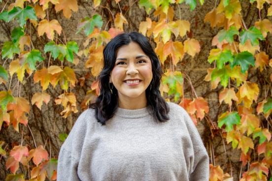 Woman standing in front of a wall of changing leaves