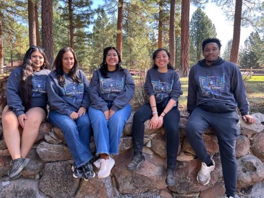 Group of people sitting on a rock wall